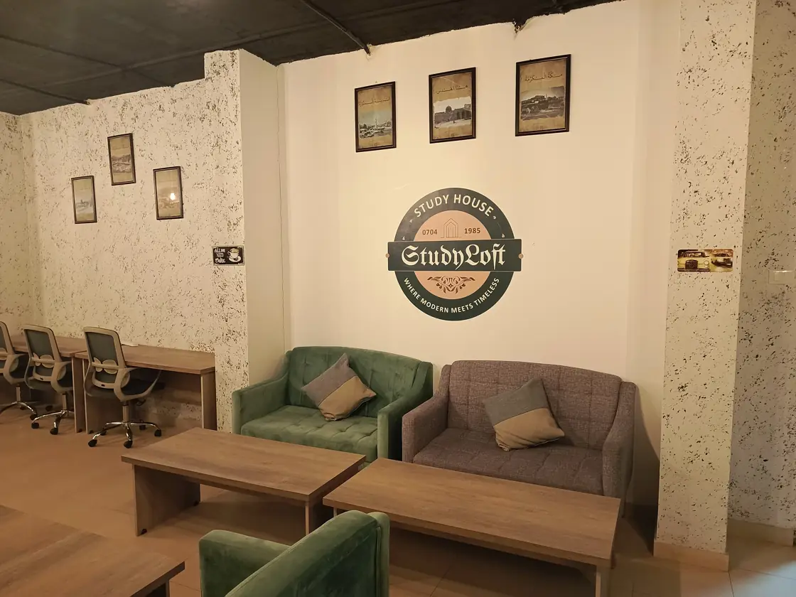 The Study Loft wall sign above green and grey lounge chairs beside wooden study tables